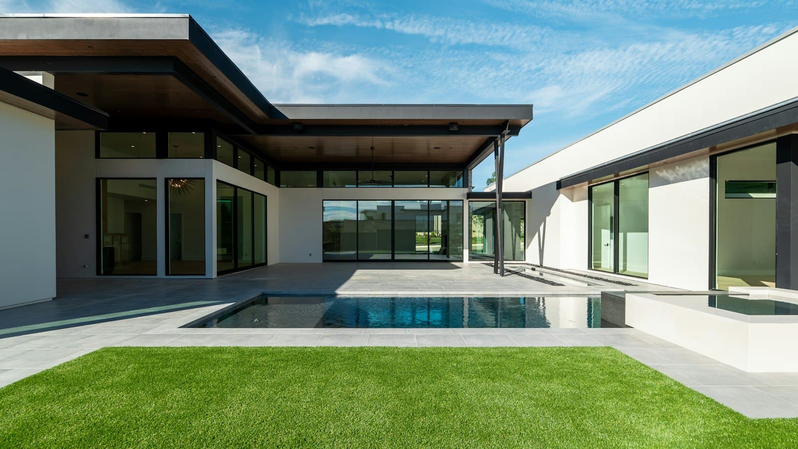 Modern home with a pool and a green lawn