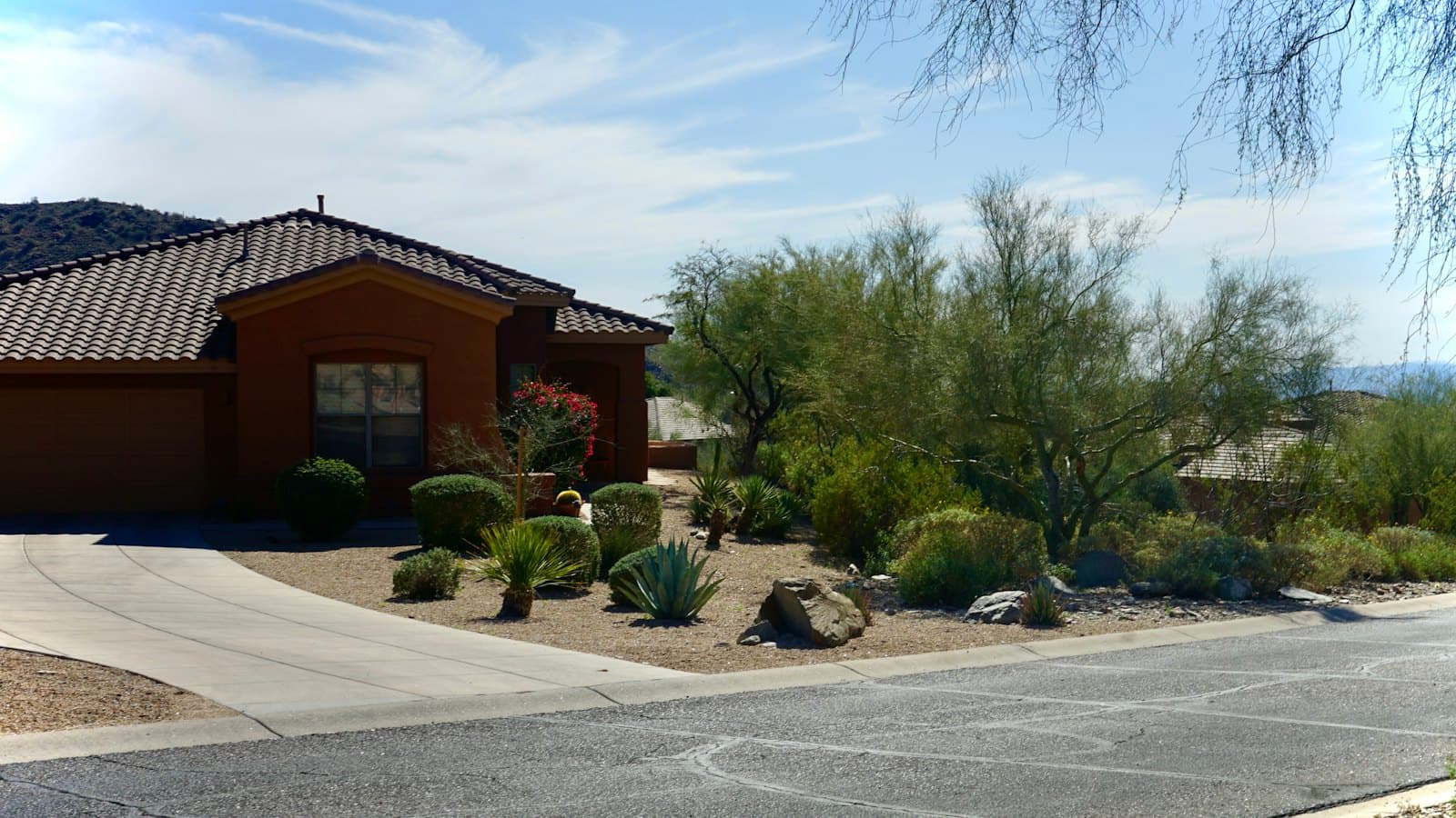 Tile-roofed stucco home with low-water desert landscaping