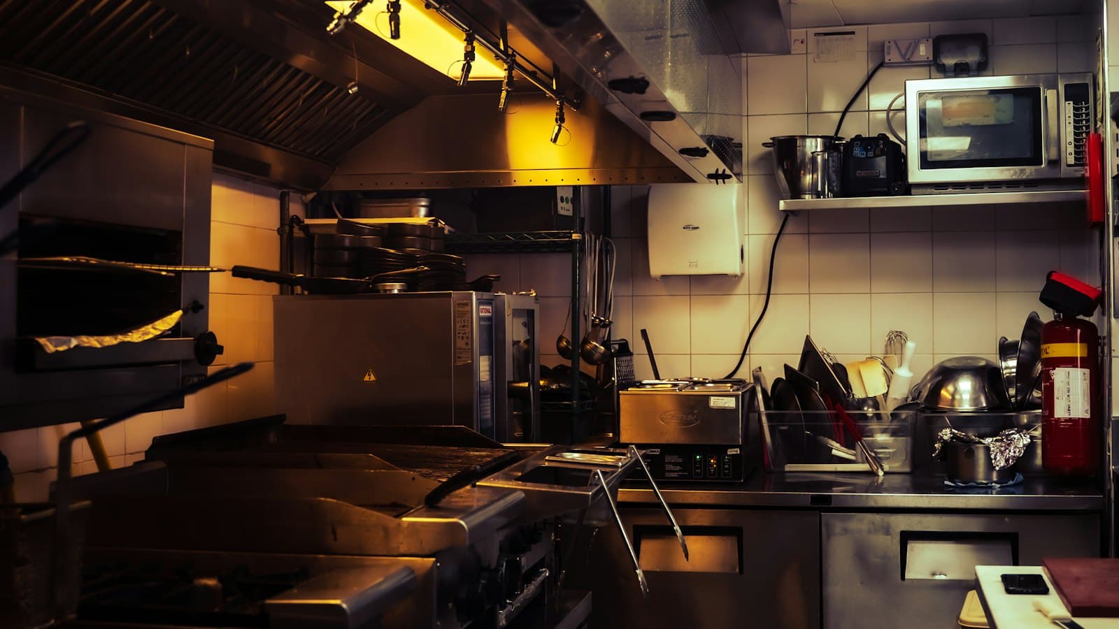 Clean, empty commercial kitchen with stainless steel equipment