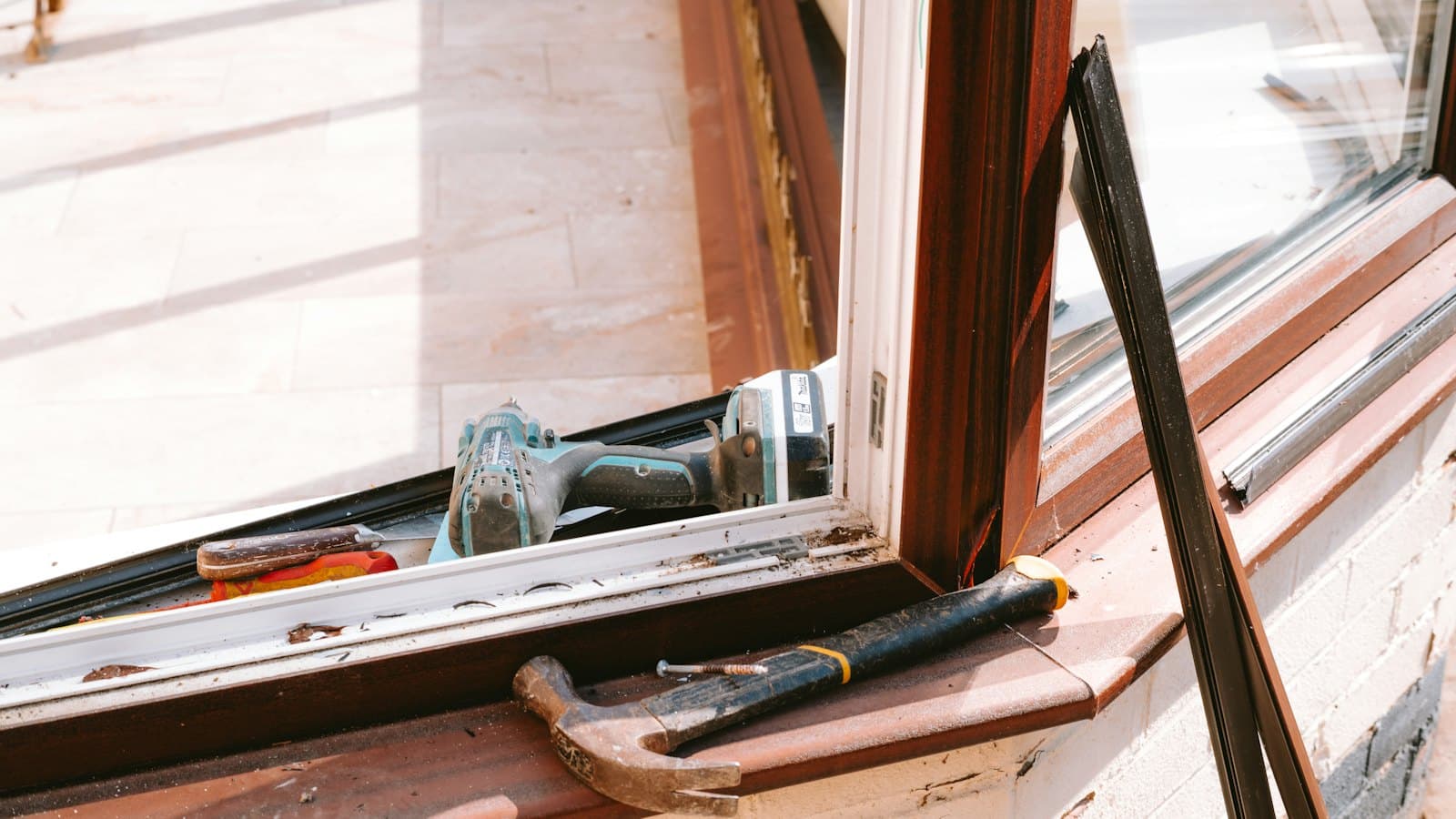 Hammer and tools on a window sill during a DIY repair