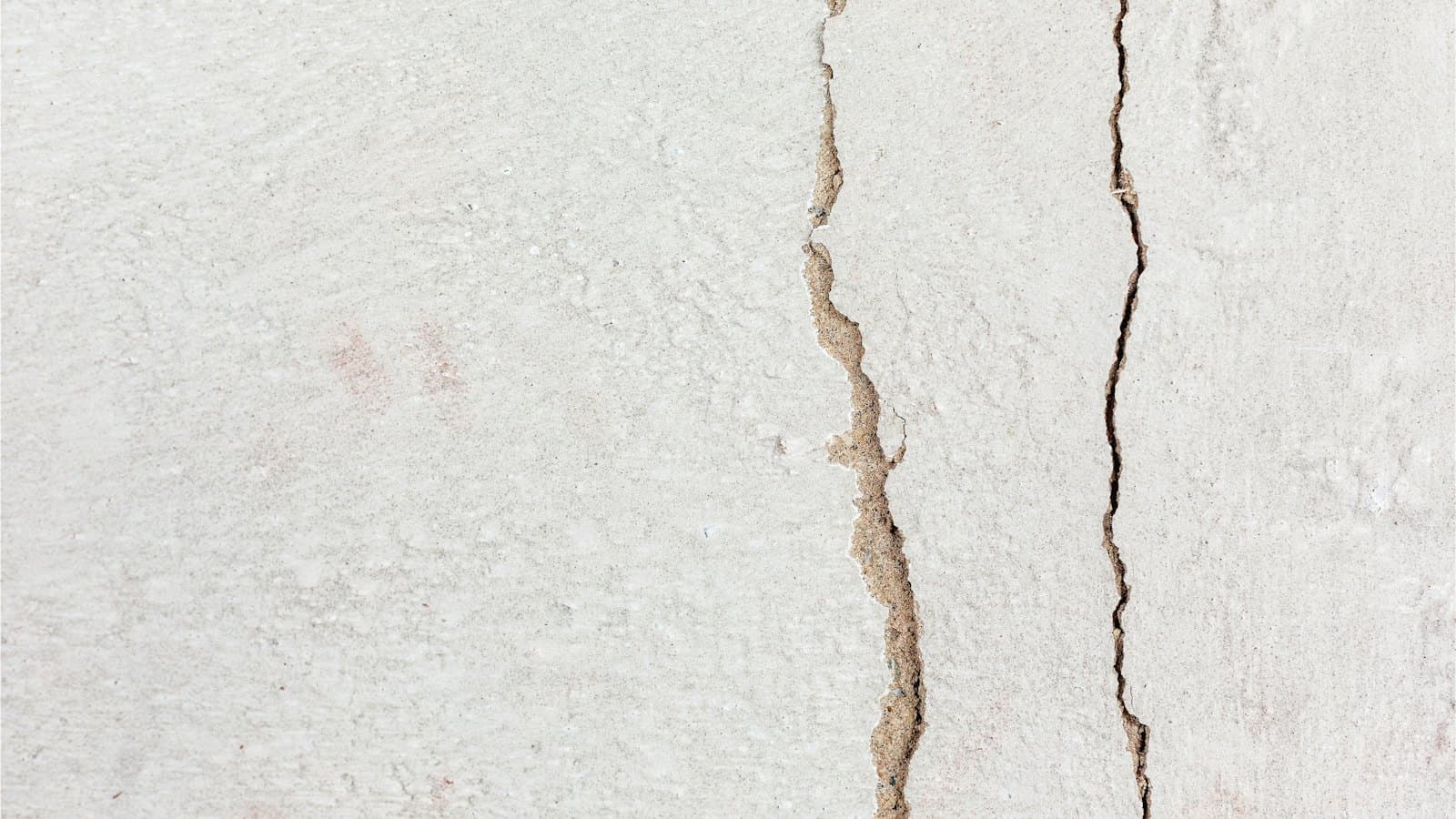 Cracks running through an exterior stucco wall