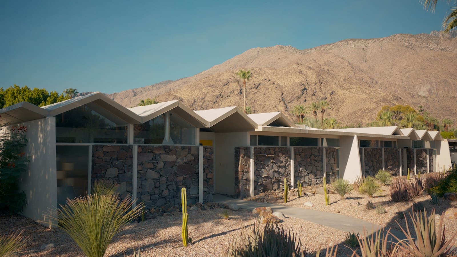 Desert home with agave and cactus landscaping below a dry mountain